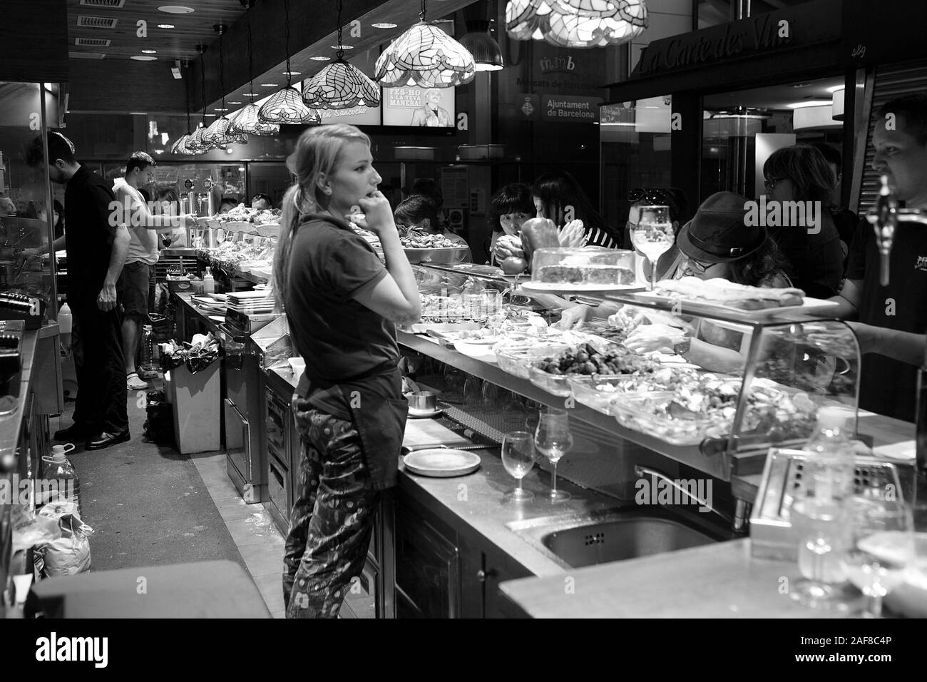 Menschen sitzen und arbeiten Mitarbeiter in eine Snackbar im Mercado de La Boqueria in Barcelona. Stockfoto