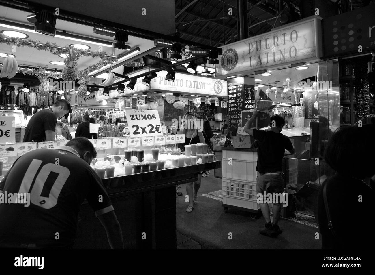 Monochromes Bild von Marktständen verkaufen verschiedene Getränke und innerhalb der Mercado de La Boquerioa in Barcelona. Stockfoto