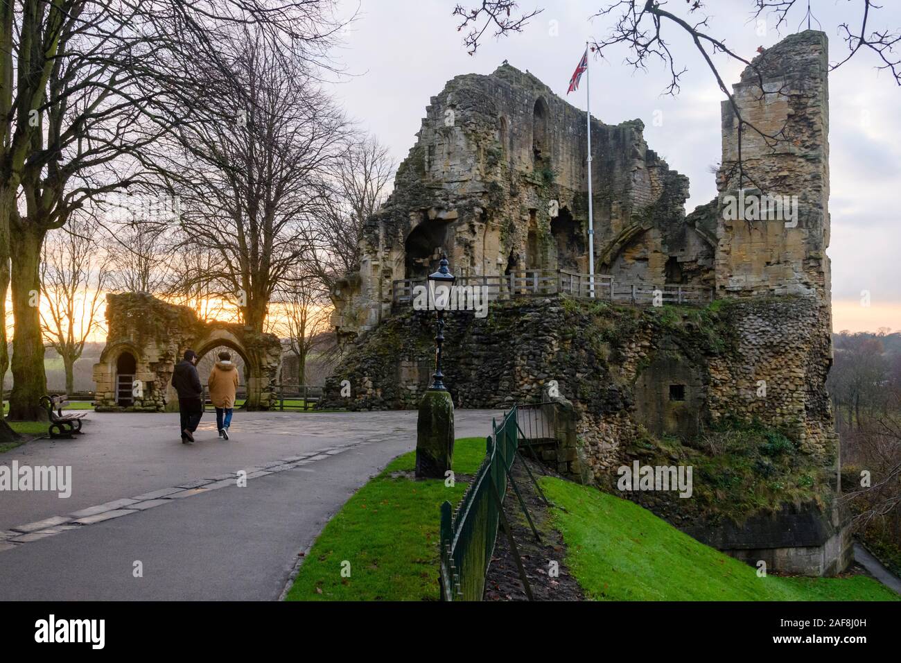 Am Abend Sonnenuntergang und zwei Leute zusammen Wandern im malerischen Park, der von mittelalterlichen Turm halten & Ruinen von knaresborough Schloss - North Yorkshire, England, GB, UK. Stockfoto