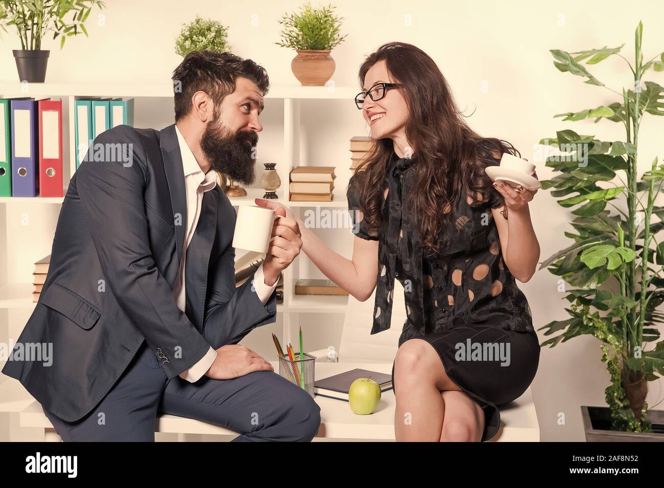 Flirten Kollegen. Mann und attraktive Frau mit Bart. Mann und Frau Gespräch Kaffee Zeit. Büro Kaffee. Büro Gerüchte. Paar Kollegen Kaffeepause entspannen. Teilen Kaffee mit Kollegen. Stockfoto