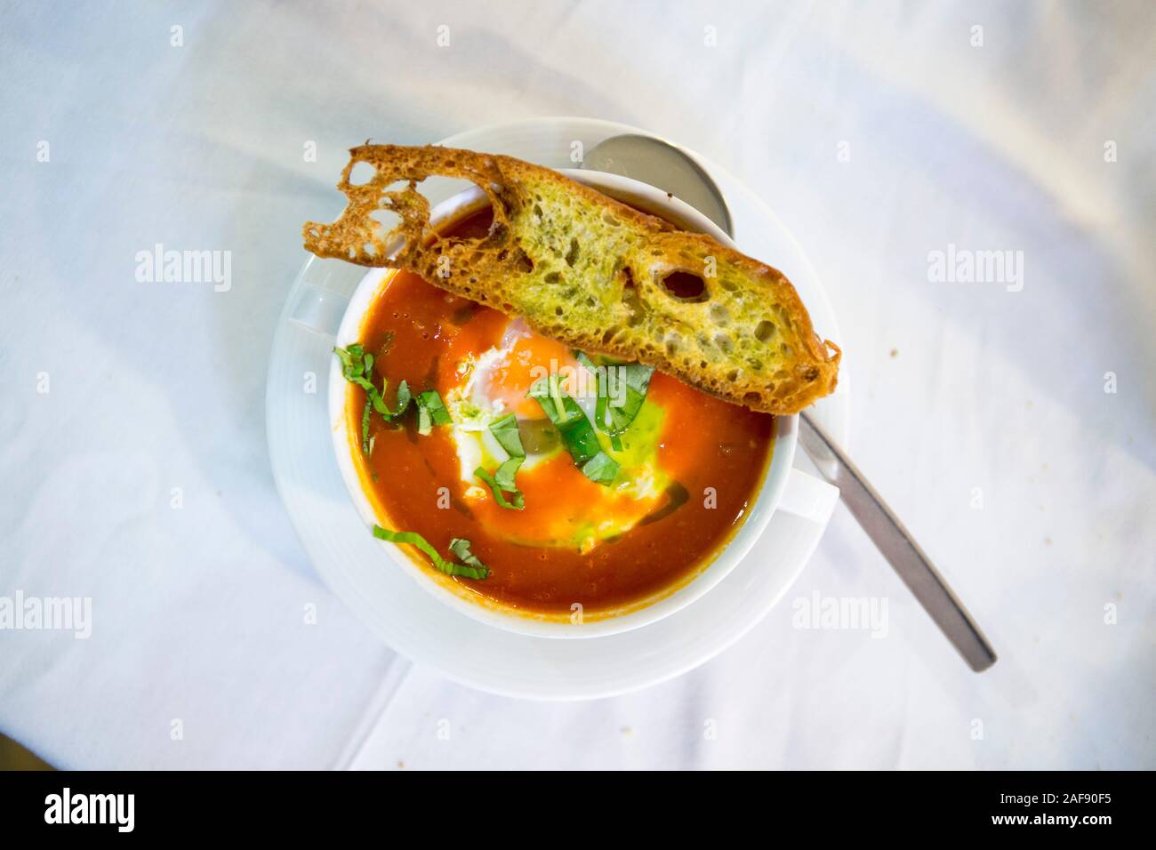 Portugiesisch Tomato und Pochierte Eiersuppe (Sopa de Tomate com Ovos Escalfados) mit hausgebackenem Brot Stockfoto