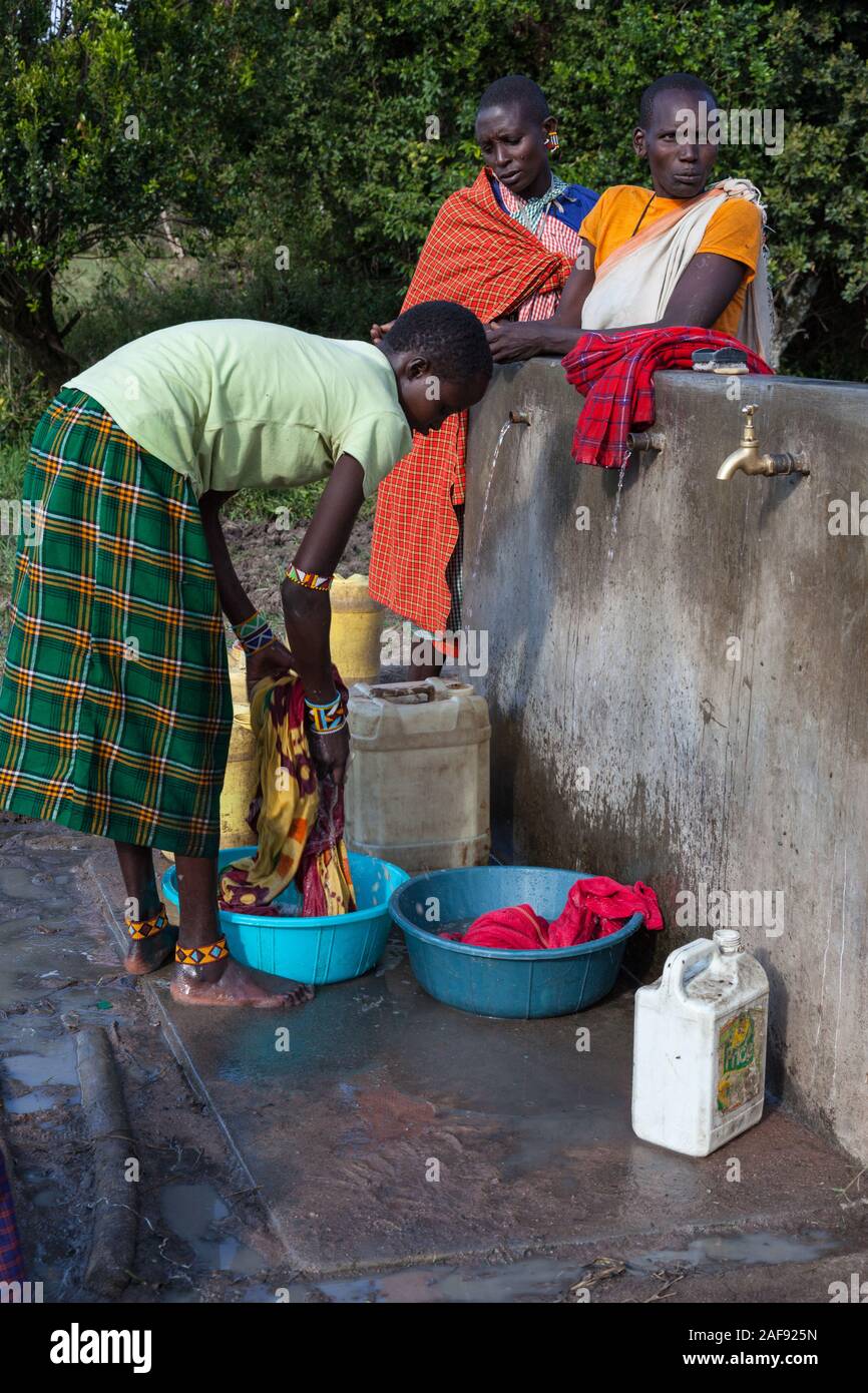Tansania. Massai-frau ihre Wäsche, Ololosokwan Dorf, nördliche Serengeti. Stockfoto