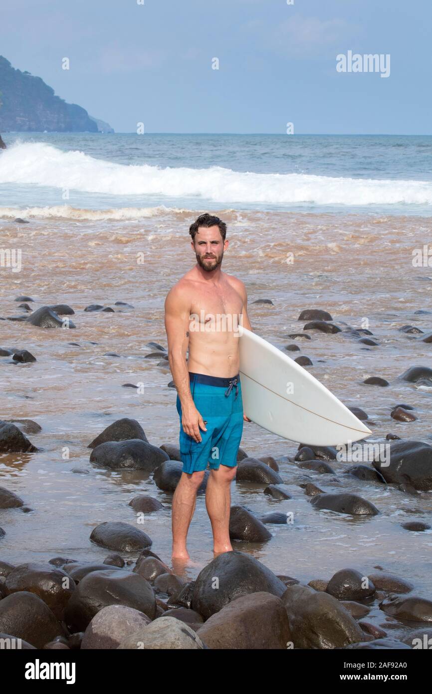 Eine junge männliche Surfer an der pazifischen Küste Strand in El Salvador, Mittelamerika Stockfoto