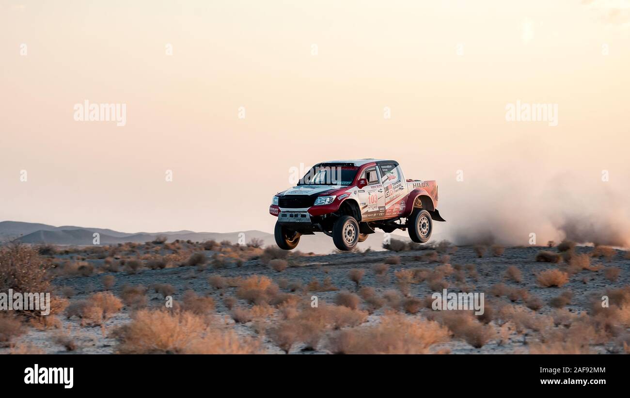 zahedan, baluchestan-iran- juli 27 2021 toyota Hulux dakar Rallye-Edition sprang in die Luft und spritzte Staub zurück bei Sonnenuntergang in Dasht e lut Wüste Stockfoto