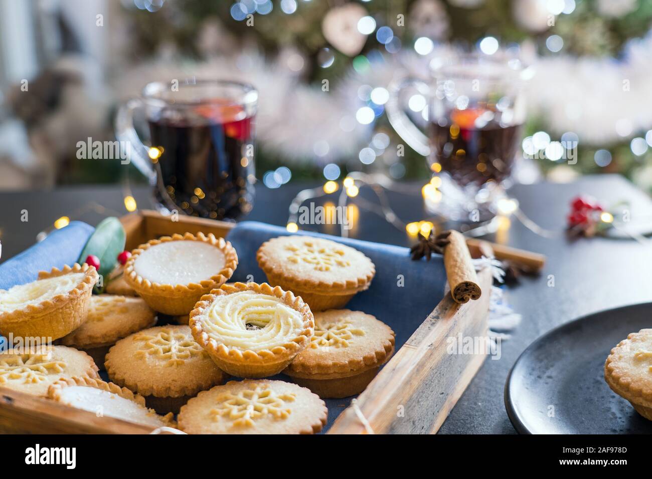 Warme gemütliche Zusammensetzung des traditionellen englischen festliches Gebäck Torten in Holz- Fach mit unscharfen Hintergrund Glühwein getränke Hackfleisch, Scheinwerfer Girlande ein Stockfoto