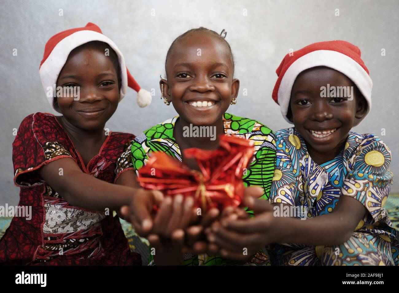 Nahaufnahme von drei wunderschöne afrikanische Kinder mit Weihnachtsgeschenk Geschenk Stockfoto