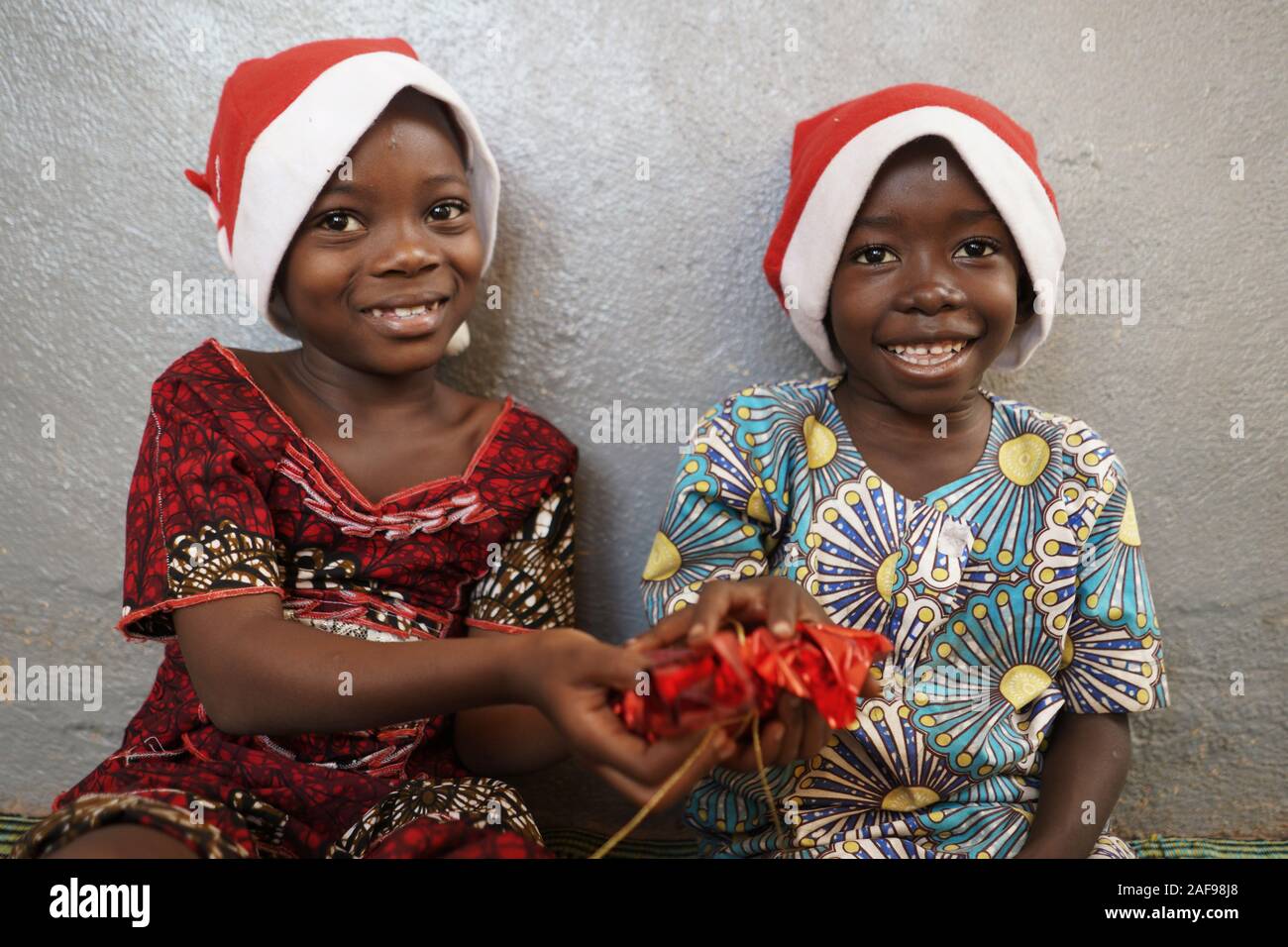 Afrikanisches Mädchen gibt Weihnachtsgeschenk Geschenk zu ihrem Bruder Stockfoto