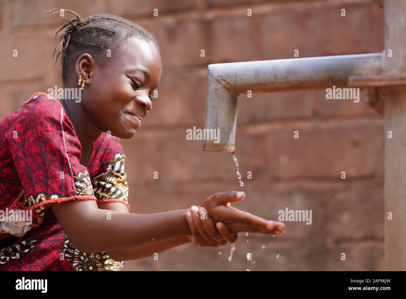 Afrikanischer Black Boy, der seinen Kopf mit Frischem, Sauberem Wasser waschen kann Stockfoto