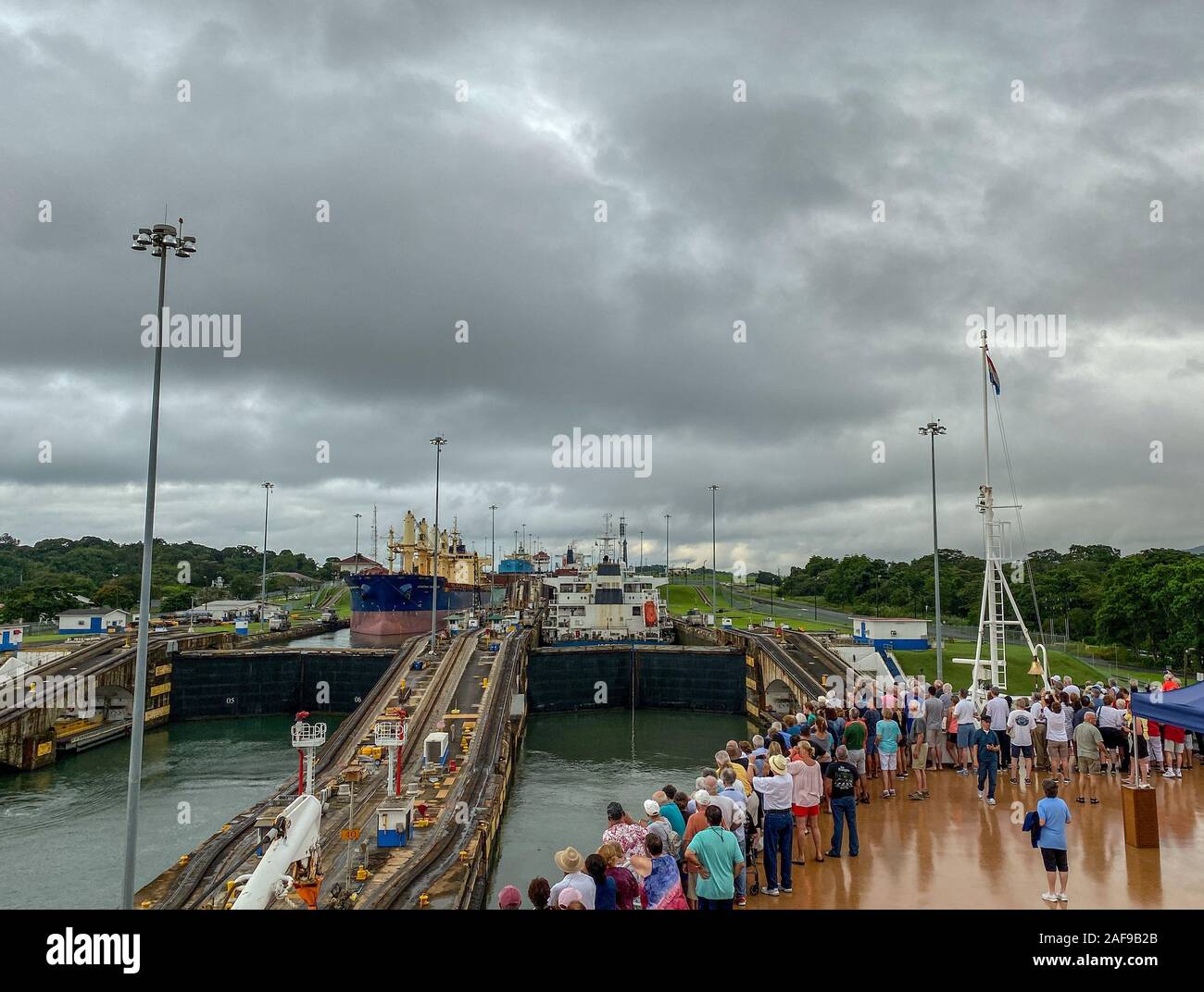 Panama - 11/6/19: ein Kreuzfahrtschiff mit den Passagieren auf dem Bug des Schiffes beobachten die erste Schleuse des Panamakanals eingeben. Stockfoto