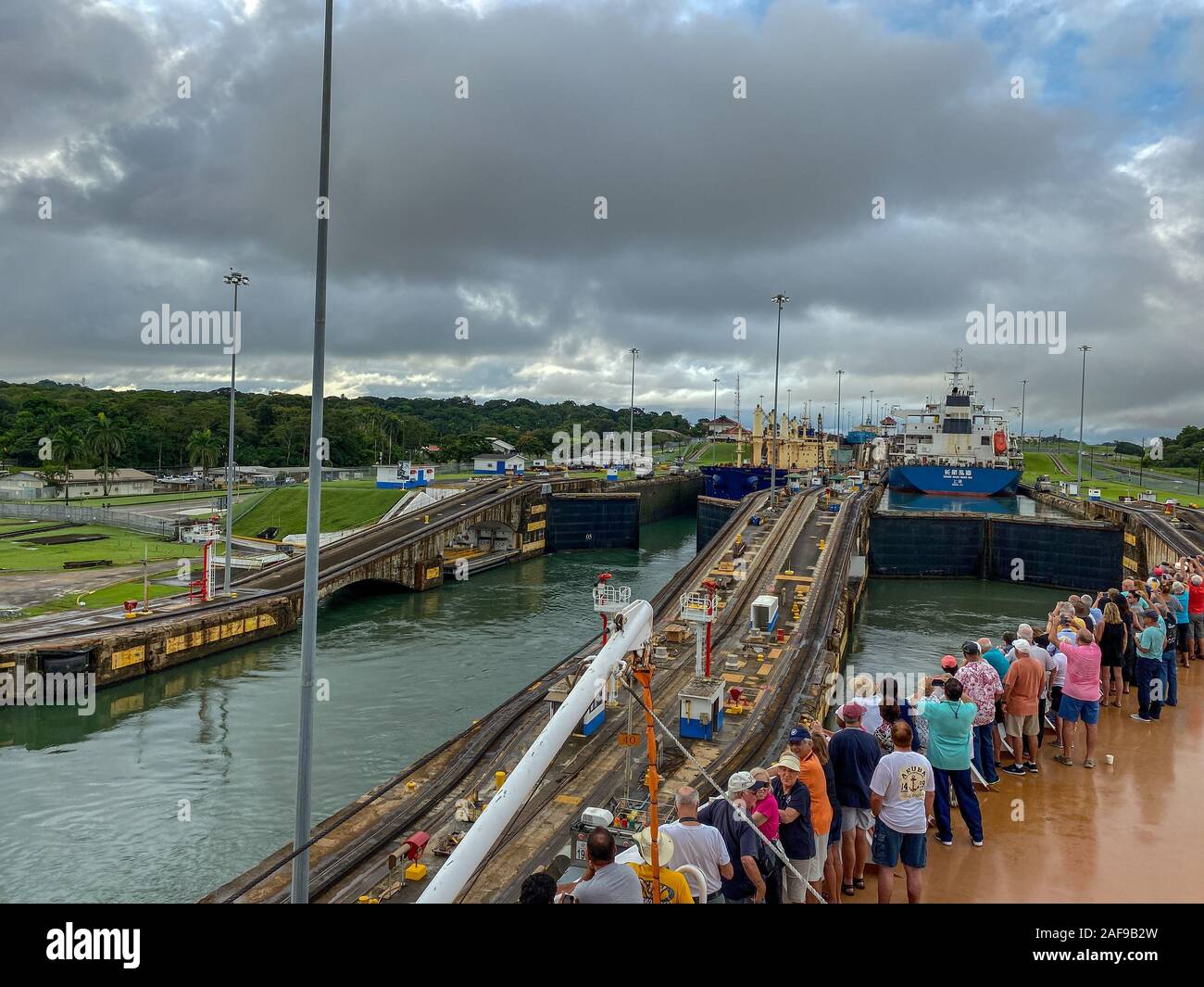 Panama - 11/6/19: ein Kreuzfahrtschiff mit den Passagieren auf dem Bug des Schiffes beobachten die erste Schleuse des Panamakanals eingeben. Stockfoto