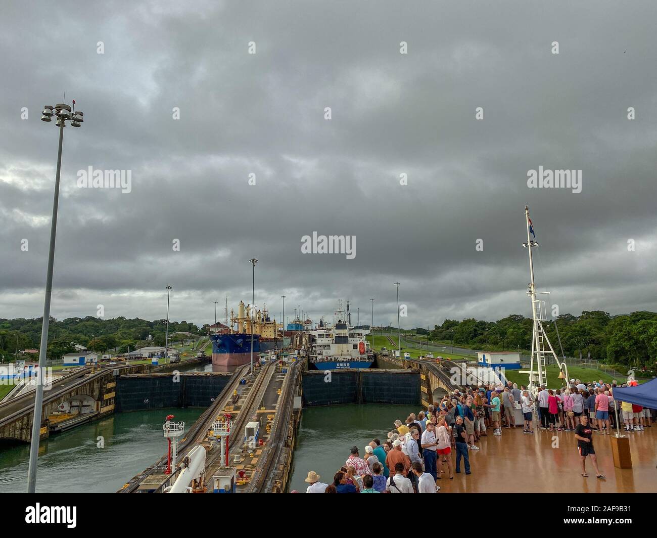 Panama - 11/6/19: ein Kreuzfahrtschiff mit den Passagieren auf dem Bug des Schiffes beobachten die erste Schleuse des Panamakanals eingeben. Stockfoto