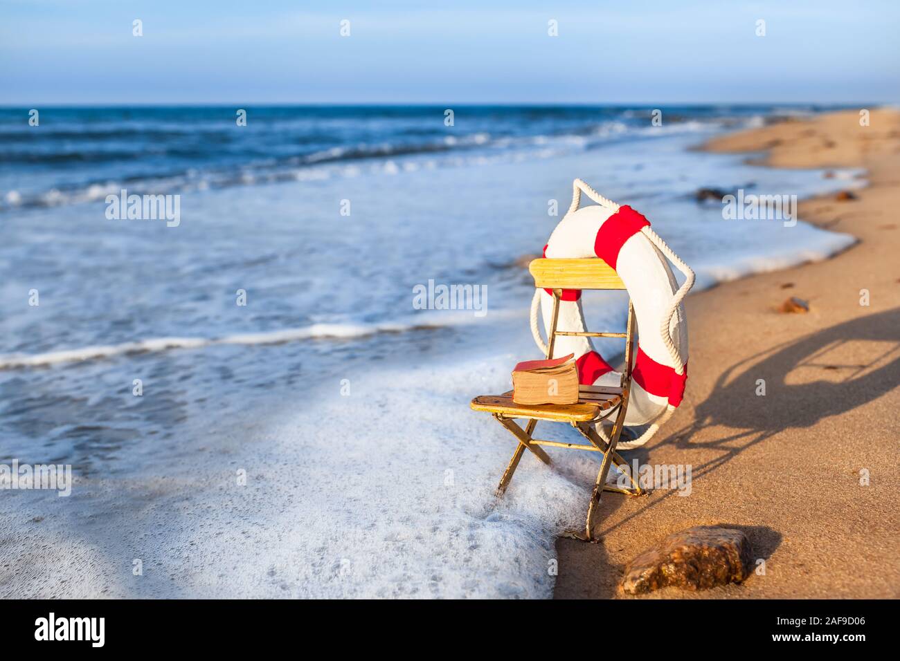 Vintage Ferienhäuser Szene miniatur Garten Stuhl am Strand Ufer wave, durch nostalgische Leben eingerichtet Boje und Buch (Kopie) Stockfoto