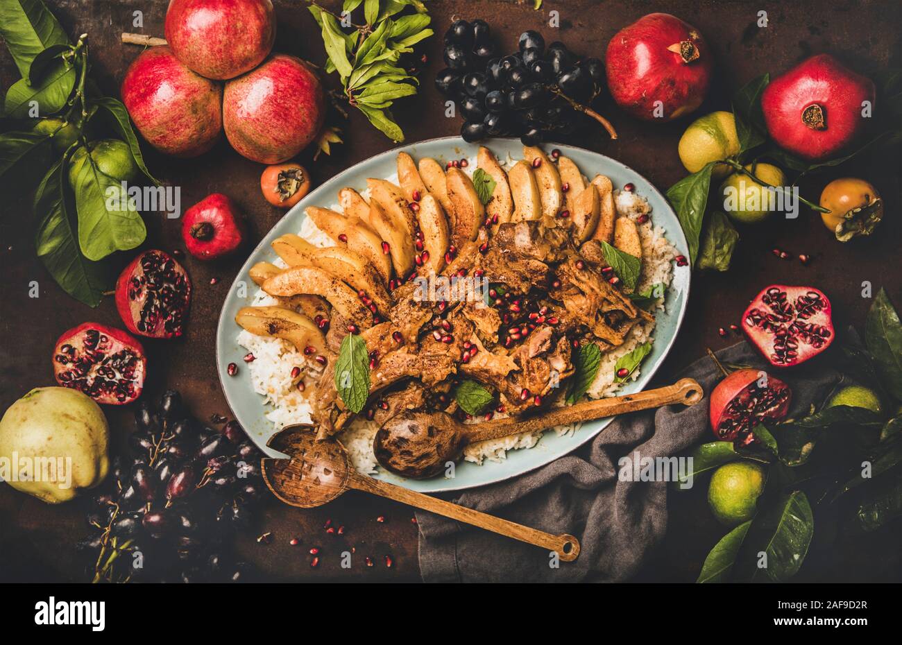Türkische traditionelle Fleischgericht. Flachbild-lay der gebratenen Lammkoteletts mit Quitten und Reis Pilav über der Platte rustikalen braunen Tisch Hintergrund diente, Ansicht von oben. Stockfoto