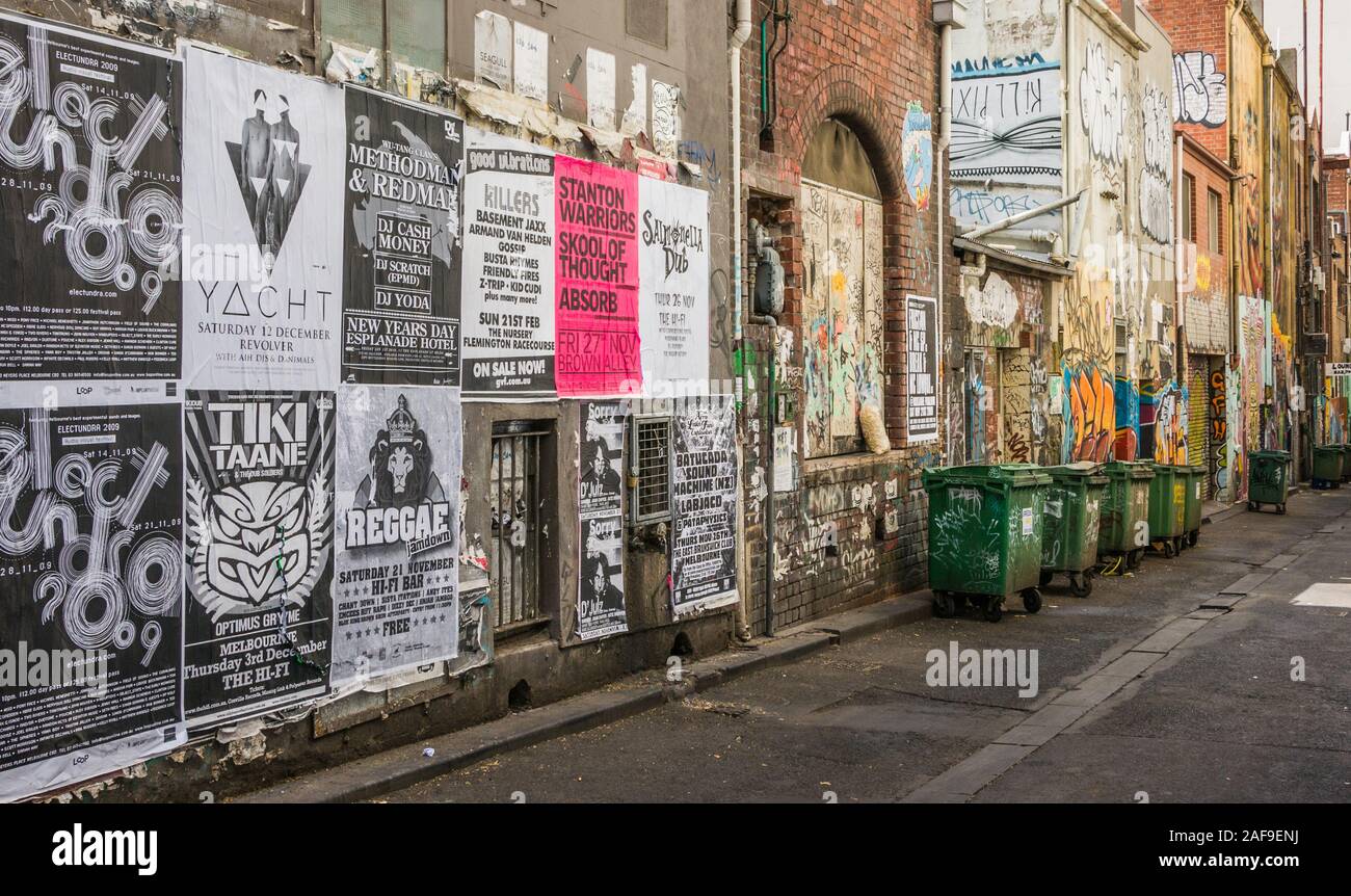 Melbourne, Australien - 17. November 2009: Gasse mit Wand bei Schwarz-weiss Poster und Graffiti verputzt, und grünen Abfalleimer i Stockfoto
