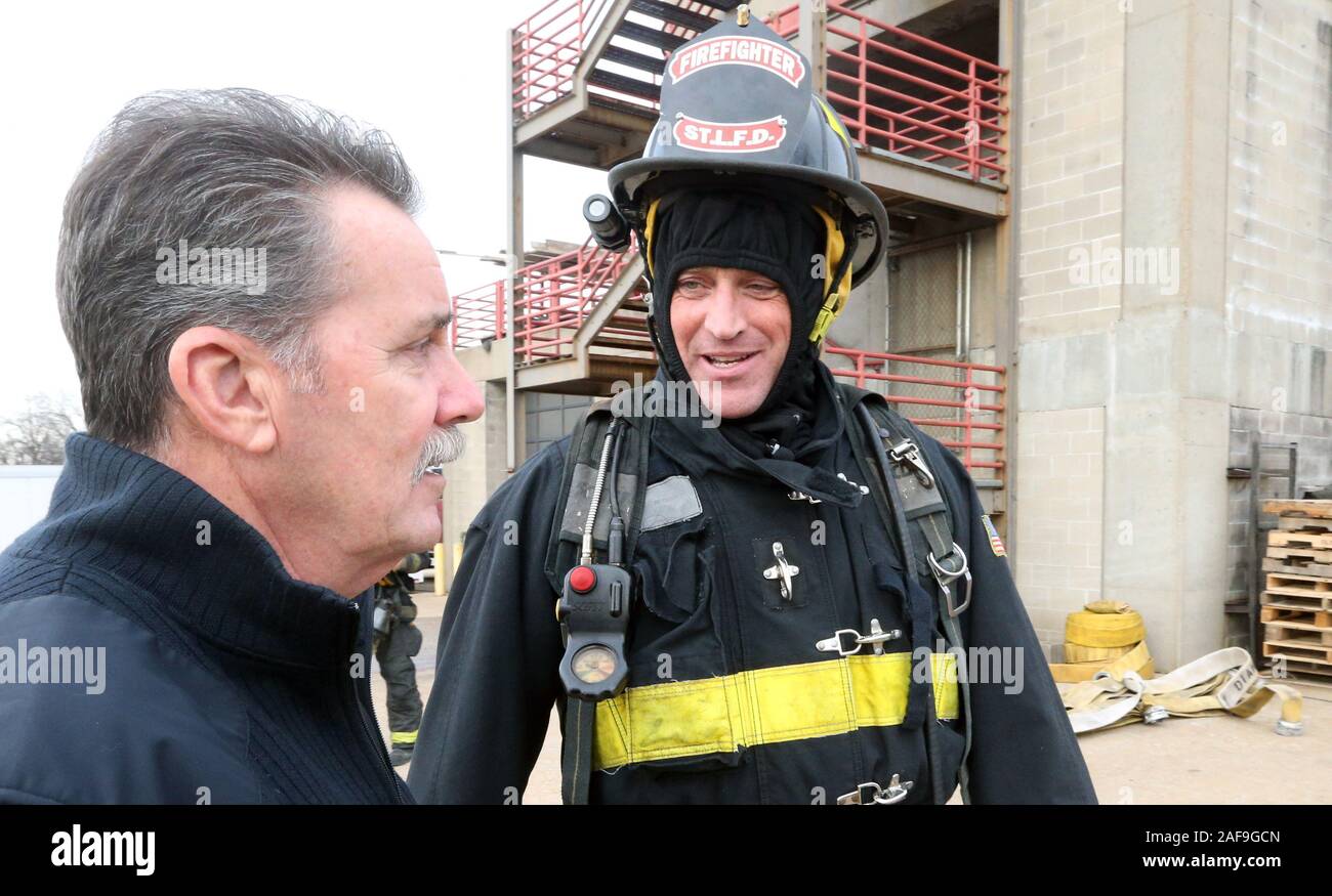 St. Louis, USA. 13 Dez, 2019. Fernsehen host des A&E zeigen "Leben retten" Matt gesagtes Iseman, (R) Gespräche mit St. Louis Fire Chief Dennis Jenkerson, bevor Sie eine Live Brennen mit dem St. Louis Feuerwehr in St. Louis am Freitag, 13. Dezember 2019. Gesagtes Iseman, am Besten als der Wirt des 'American Ninja Warrior' gekleidet in voller Brandbekämpfung Gang zu erleben und ein echtes Feuer löschen, seine erste. Foto von Bill Greenblatt/UPI Quelle: UPI/Alamy leben Nachrichten Stockfoto