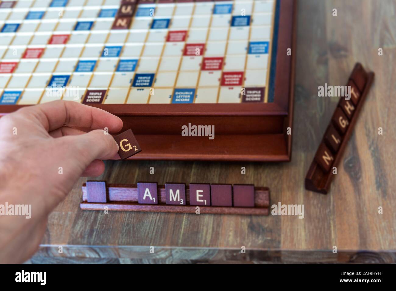 Sicht hand mit buchstabensteine beim Spielen ein Brettspiel Stockfotografie  - Alamy