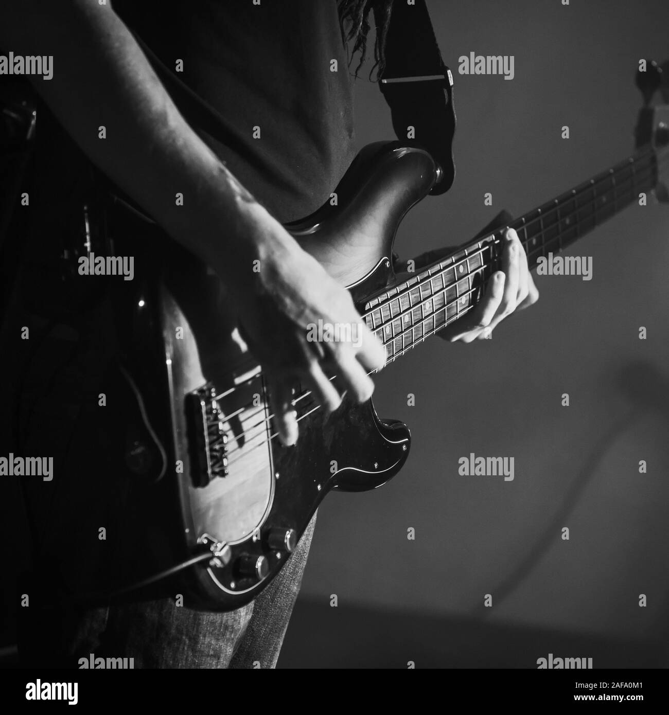 Electric Bass Guitar Player Hände, live Musik Thema. Retro stilisierte square Schwarz und Weiß Foto Stockfoto