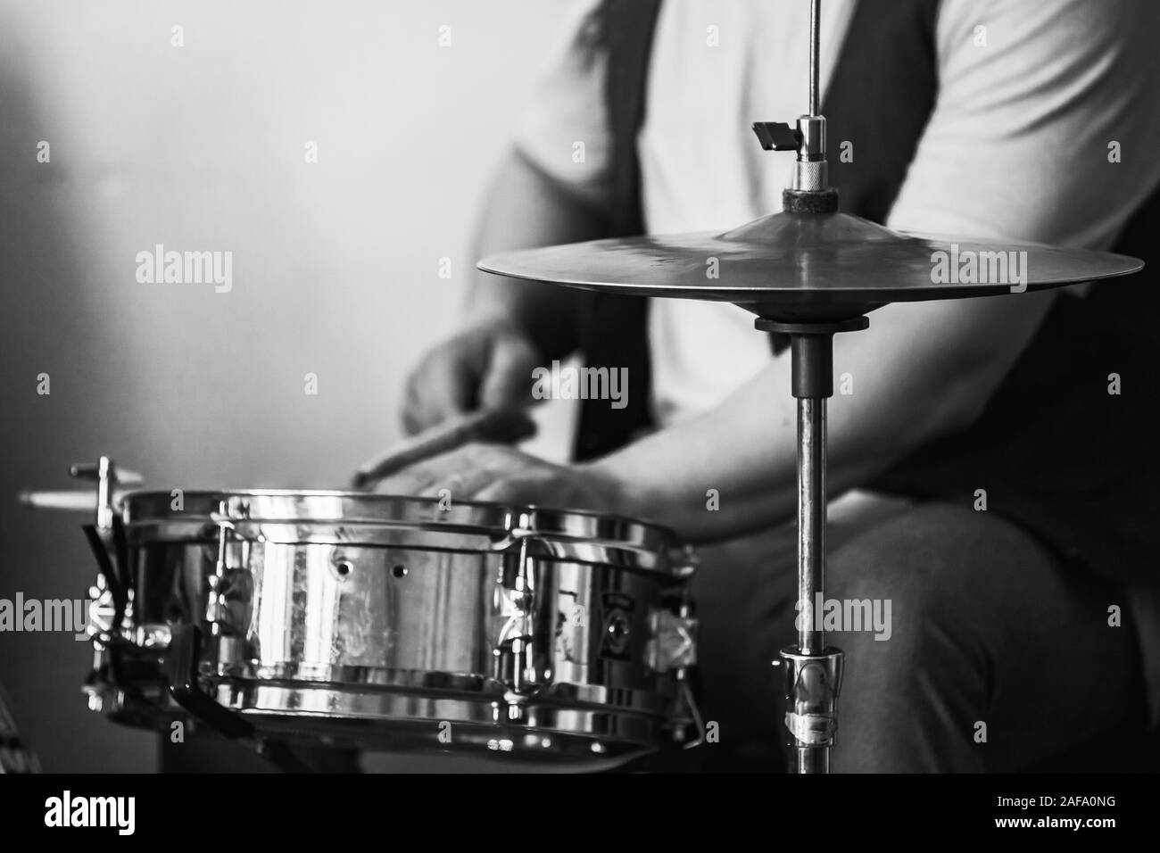 Live musik Hintergrund, Schlagzeuger spielt mit Trommelstöcken ein Drum Set. Closeup retro stilisierten Schwarzweiß-Foto Stockfoto
