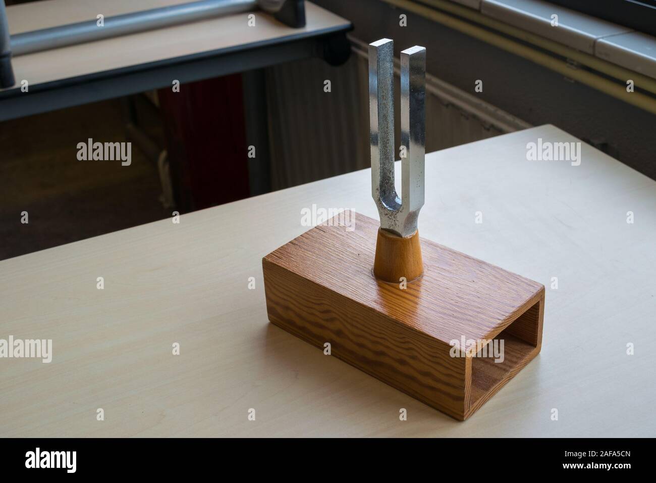 Schwinggabel auf einer hohlen Holzkiste. Die Melodie in der Box erhält in Resonanz beim Anschlagen. Stockfoto