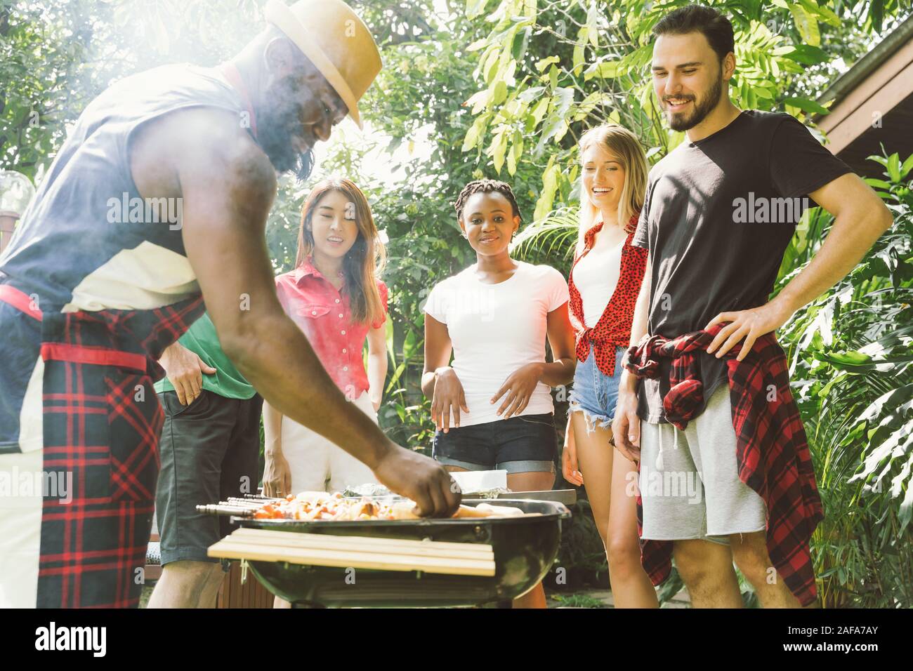 Gruppe von Menschen toasten Bier Feier und Barbecue Party Garten im Freien Stockfoto