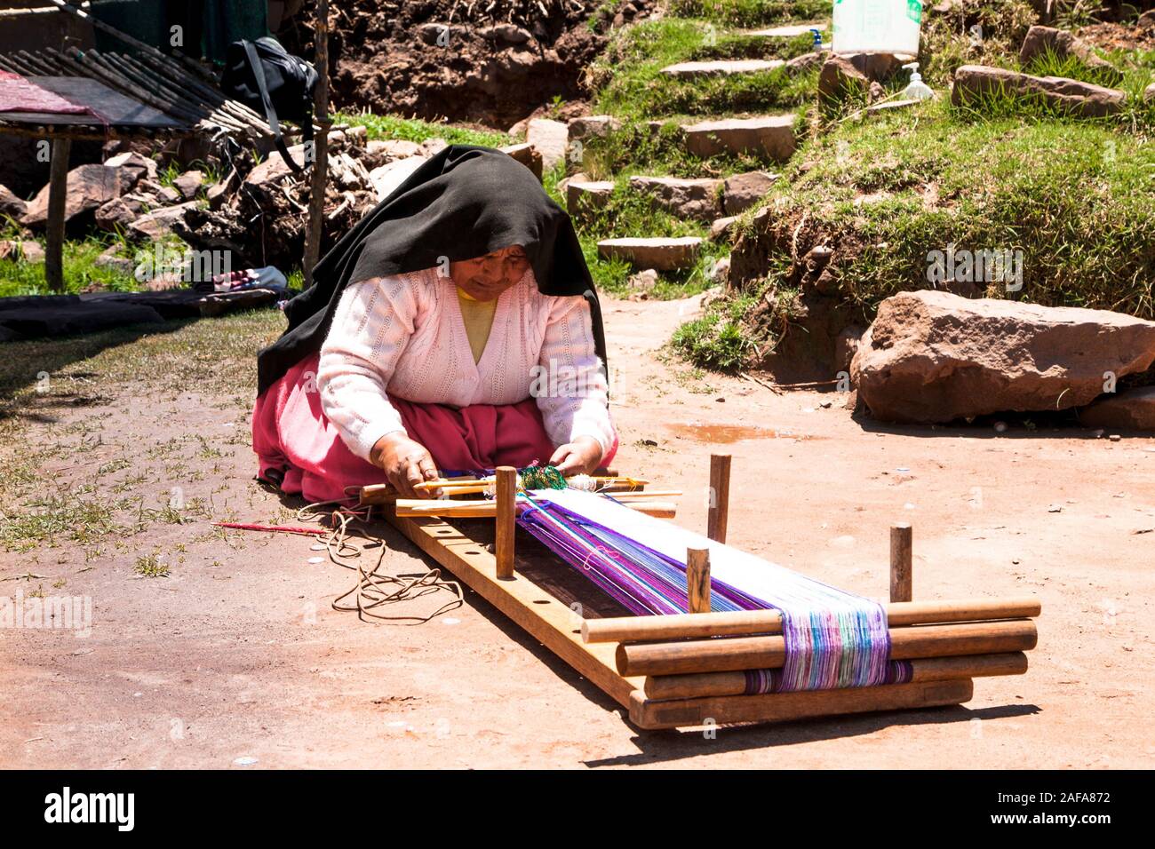 Taquile, Peru - Jan 5, 2019: Frau in traditioneller Kleidung macht Weben auf die Pause zu Insel Taquile im Titicacasee in Peru. Stockfoto