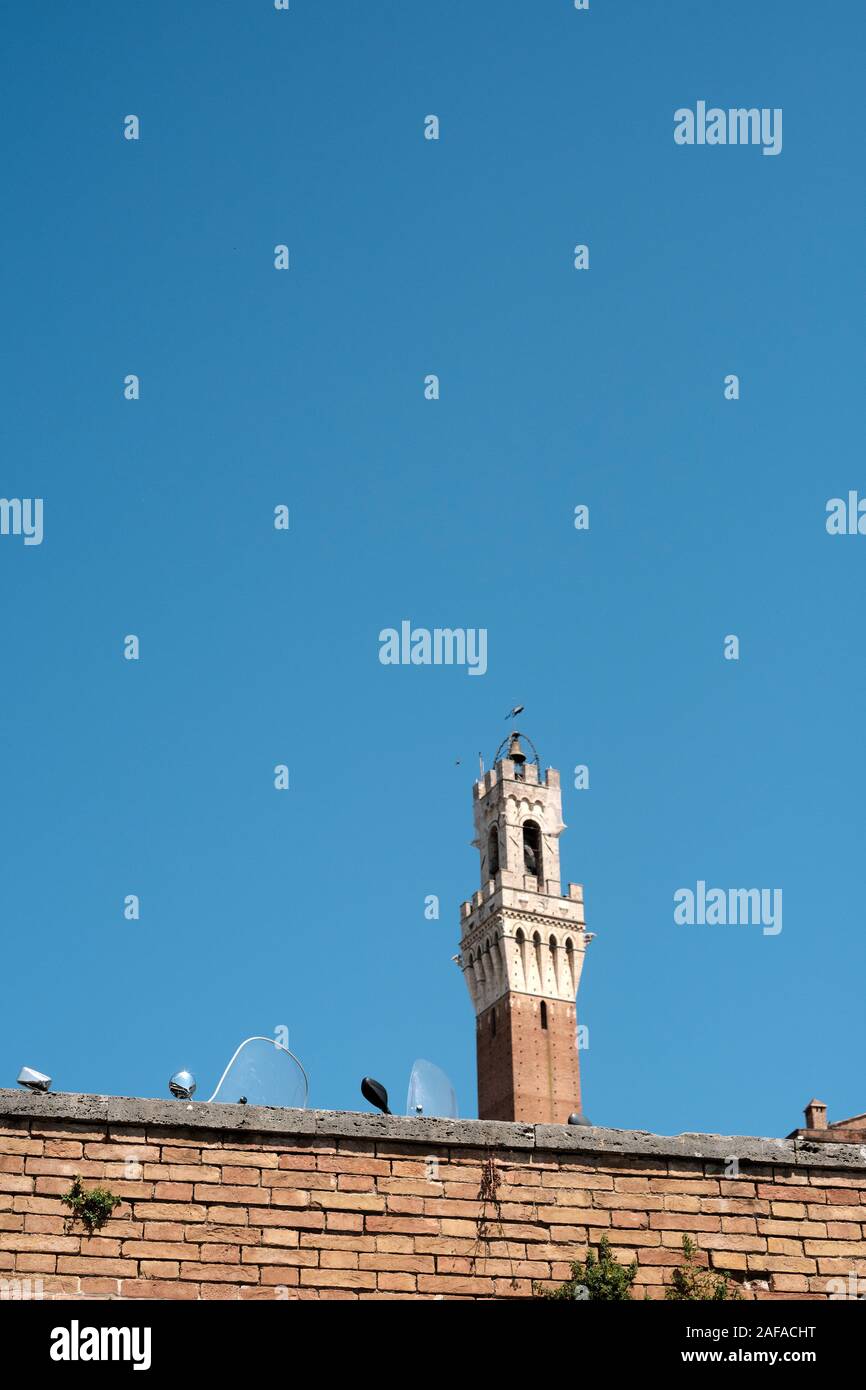 Der Torre del Mangia und geparkte Roller teilweise in das UNESCO-Weltkulturerbe von Siena, Toskana, Italien EU ausgeblendet Stockfoto