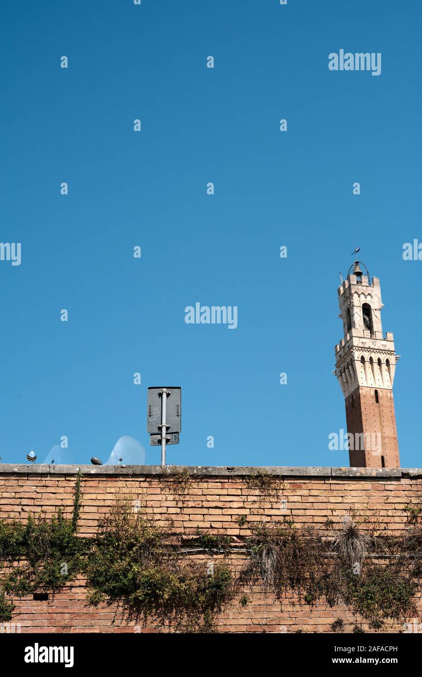 Der Torre del Mangia und geparkte Roller teilweise in das UNESCO-Weltkulturerbe von Siena, Toskana, Italien EU ausgeblendet Stockfoto