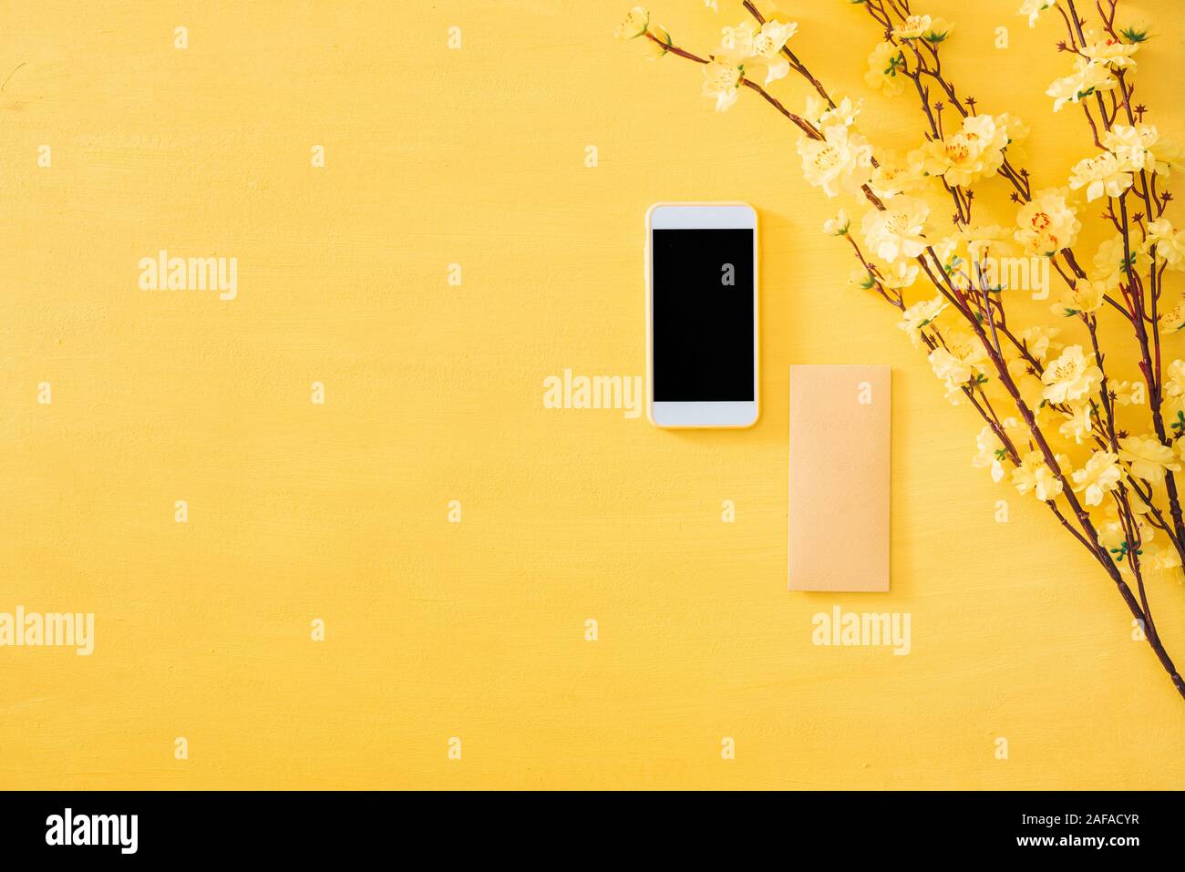 Mobiltelefon mit Chinesischen Neujahr Dekoration auf ein gelbes gold Hintergrund Stockfoto