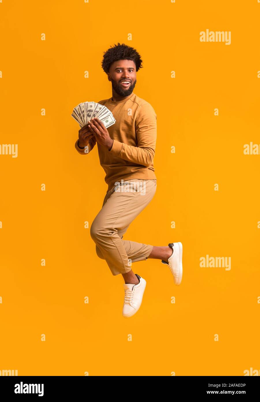 Glück schwarze Kerl springen mit Bündel von Dollar Stockfoto