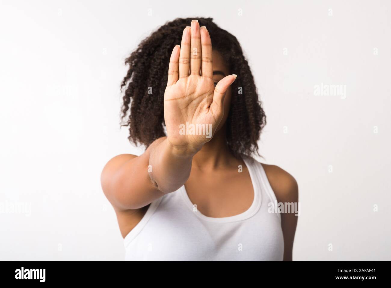 Junge schwarze Mädchen mit STOP-Schild mit weißem Hintergrund Stockfoto