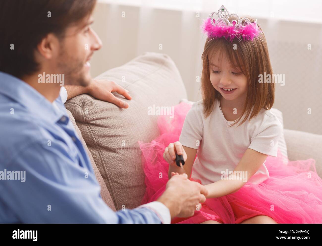 Kleines Mädchen ihr Papa Nägel Färbung mit bunten Polierer Stockfoto