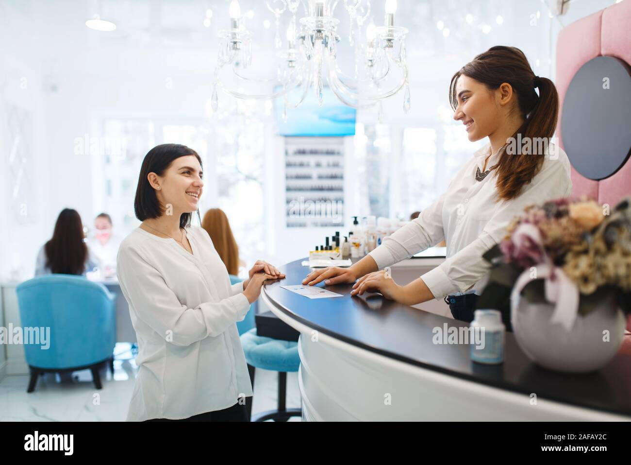 Frau spricht mit Administrator von Beauty Salon Stockfoto
