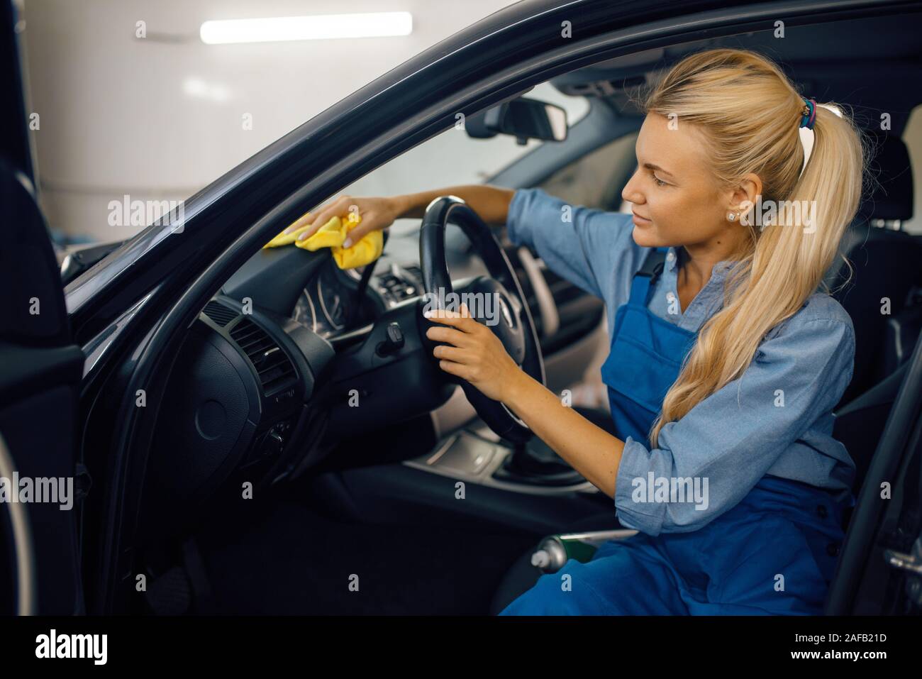 Weibliche Person mit Schwamm reinigt Fahrzeug Scheinwerfer, Auto