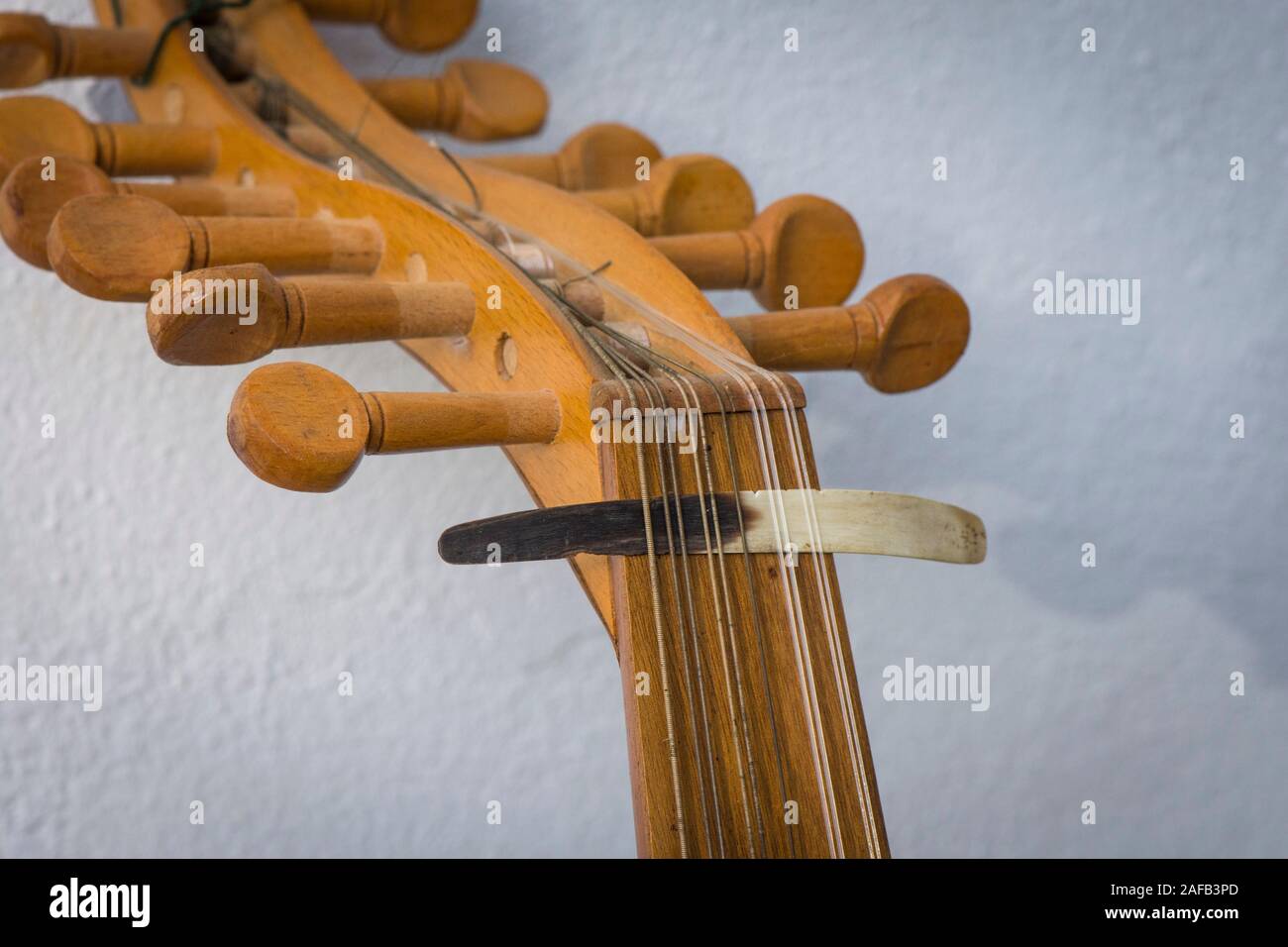 Spindelstock mit Abholung, Plektrum aus Horn, auf Strings einer alten arabischen Oud Instrument. Stockfoto
