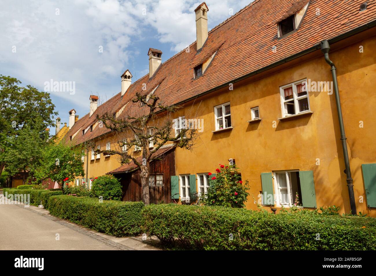 Blick auf die kleine hintere Gärten auf eine typische Straße in der Fuggerei, einen Ummauerten Enklave innerhalb der Stadt Augsburg, Bayern, Deutschland. Stockfoto