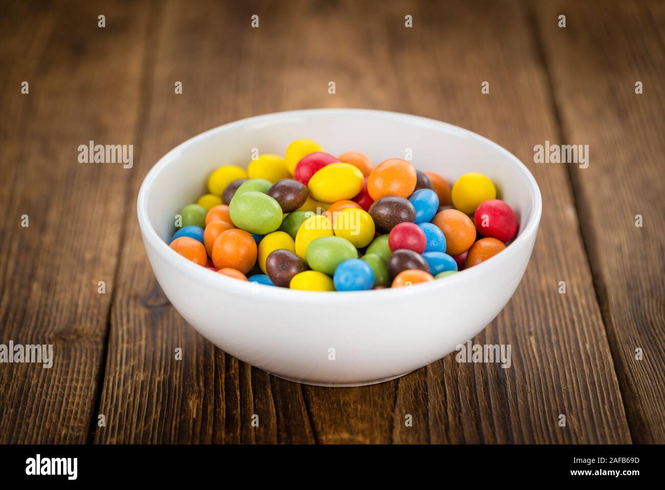 Frischen Cocolate beschichtet Erdnüsse auf einem vintage Hintergrund (Nahaufnahme) Stockfoto