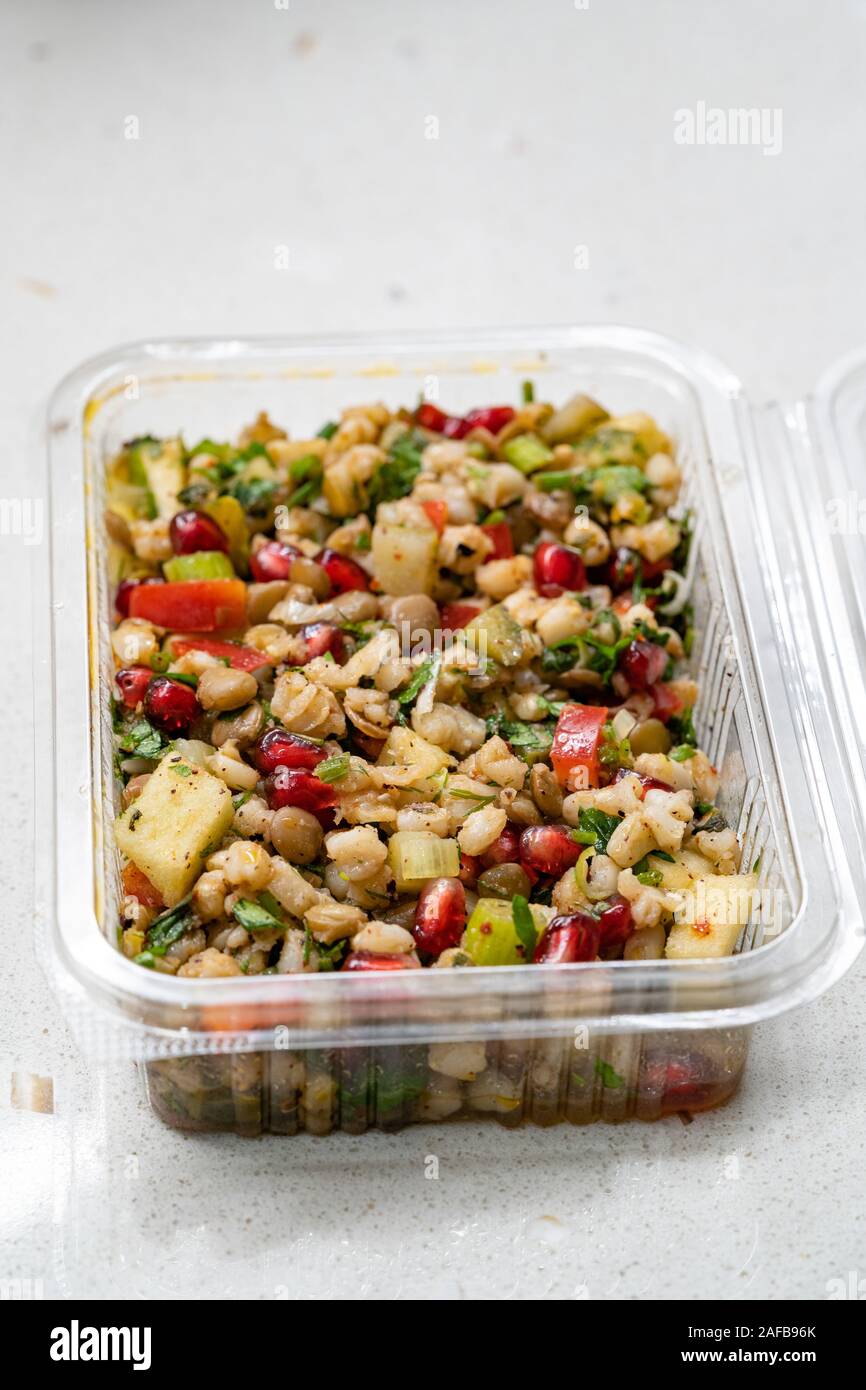 Instant Nehmen gesunde Salate mit Weizen, Linsen, Granatapfel Samen, Essiggurken und Birne Schichten in Kunststoffbox/Package Container. Ökologische Lebensmittel. Stockfoto