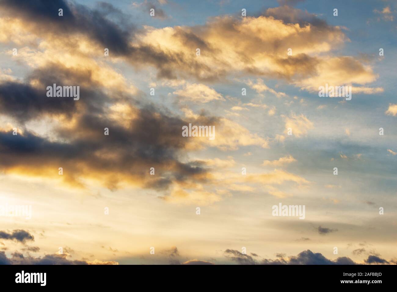 Goldene Wolken am blauen Himmel bei Sonnenuntergang. schöne Natur Hintergrund. wunderbare Atmosphäre Landschaft am Abend. Schlechte Aussichten am Abend anhand von quantitativen Simulatio Stockfoto