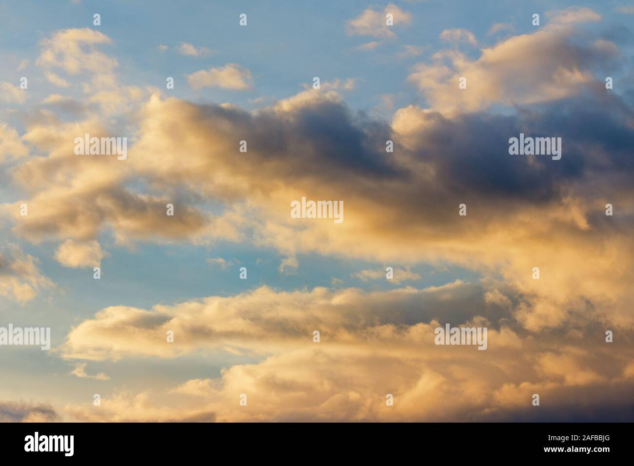 Goldene Wolken am blauen Himmel bei Sonnenuntergang. schöne Natur Hintergrund. wunderbare Atmosphäre Landschaft am Abend. Schlechte Aussichten am Abend anhand von quantitativen Simulatio Stockfoto