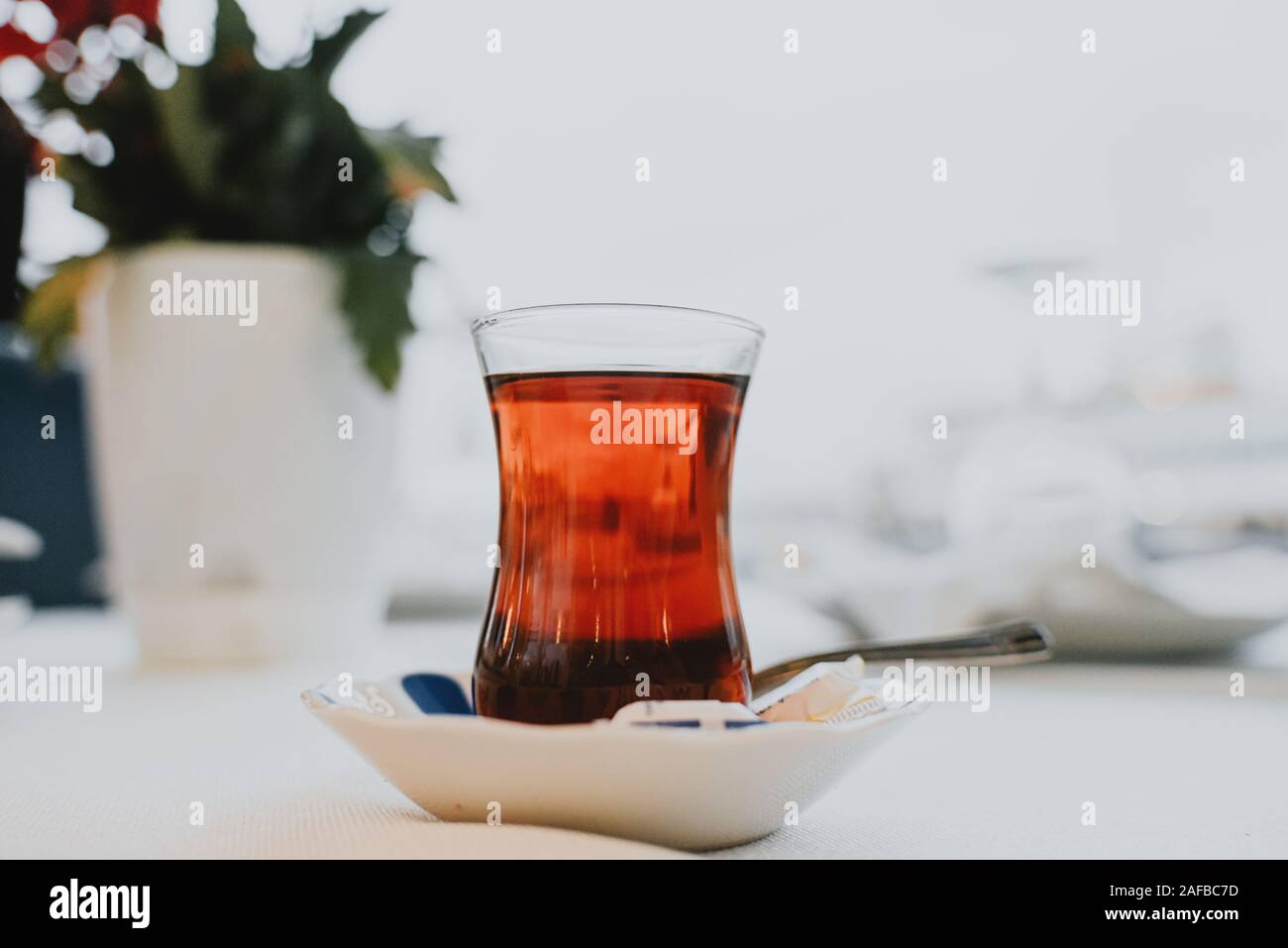 Türkischer Tee, Glas Untertasse Löffel Hintergrund verschwommen. Istanbul Stockfoto