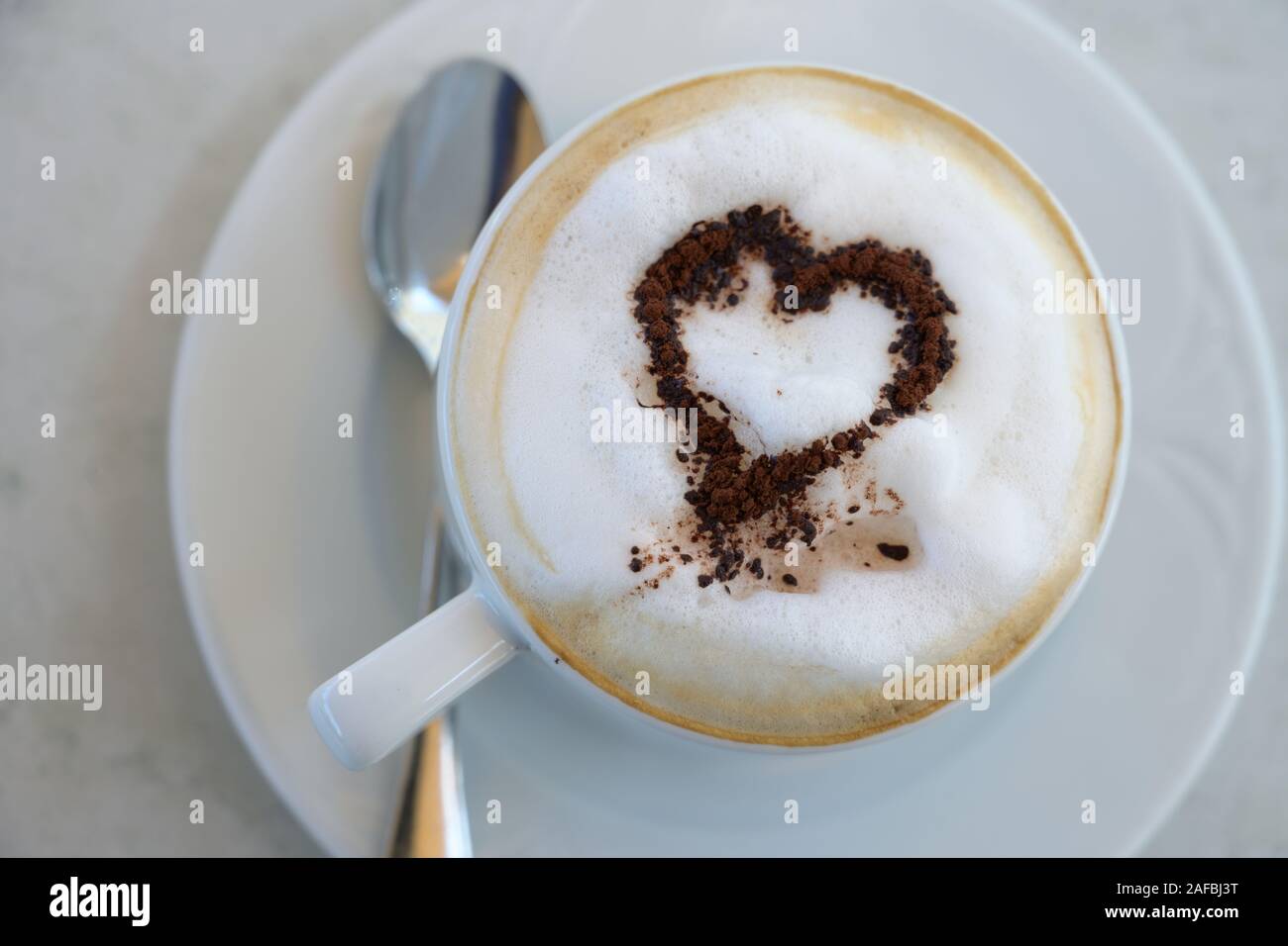 Tasse Cappuccino mit Kakao Pulver in Herz Form auf eine Tabelle in einem  Straßencafe, hohe Winkel, Ansicht von oben, ausgewählte konzentrieren, enge  Tiefenschärfe Stockfotografie - Alamy