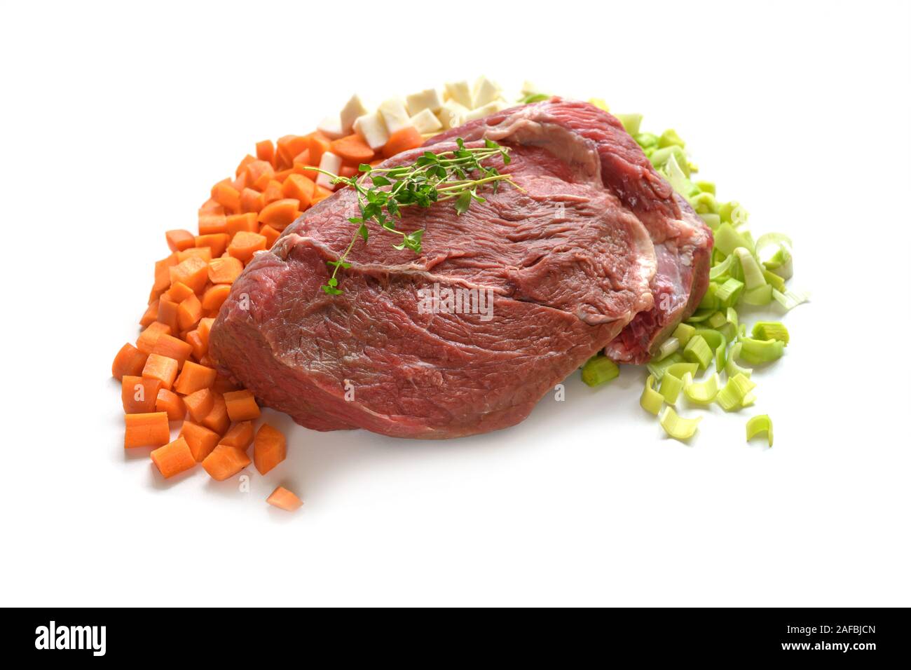 Stück rohes Rindfleisch Fleisch mit Gemüse Zutaten wie Karotten, Lauch und Sellerie, auf einem weißen Hintergrund, kopieren Raum Stockfoto