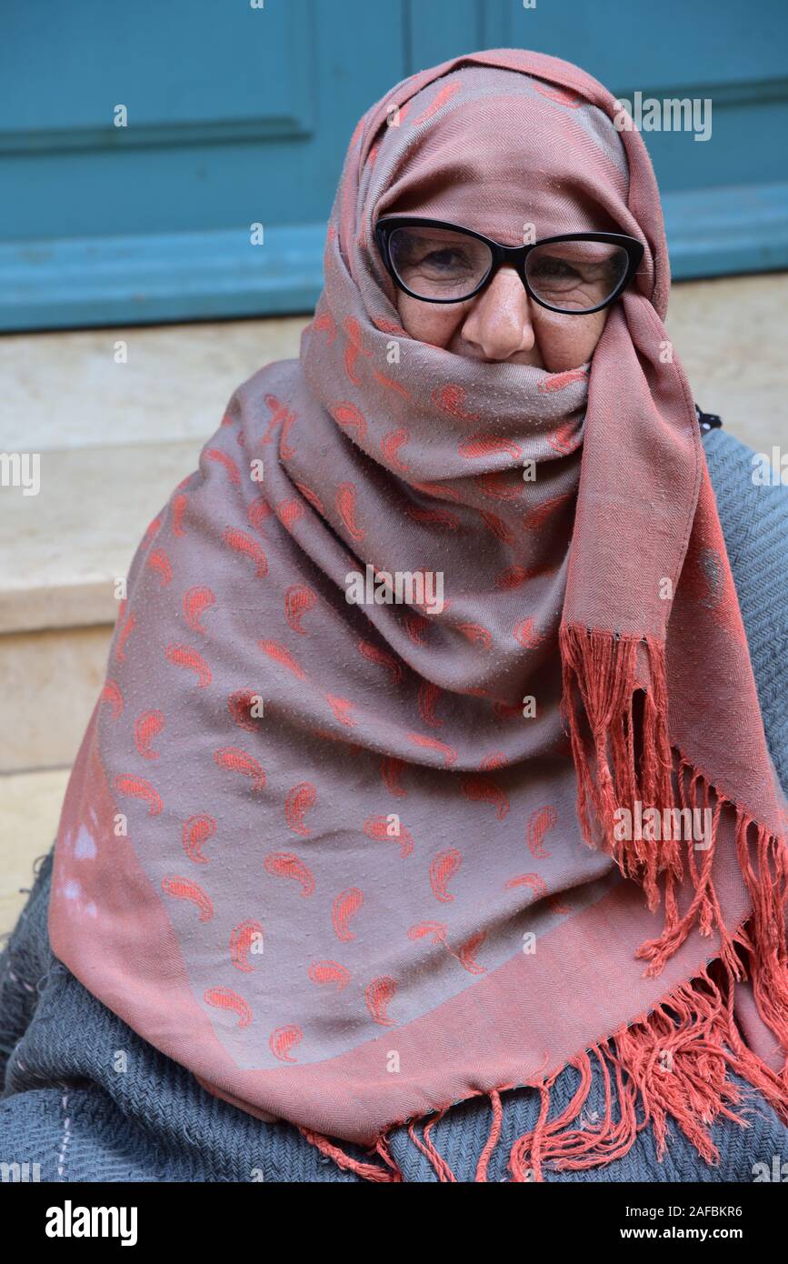 Ältere Dame, eingehüllt in eine Decke, ihr Gesicht verhüllen mit einem Schal, Essaouira, Marokko, Nordafrika. Stockfoto