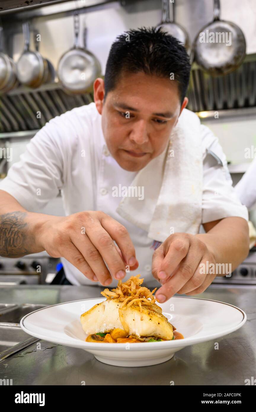 Restaurant Iguana Küchenchef setzenden Abschluss auf chilenischen Wolfsbarsch Vorspeise im Casa Kimberly, Puerto Vallarta, Jalisco, Mexiko. Stockfoto