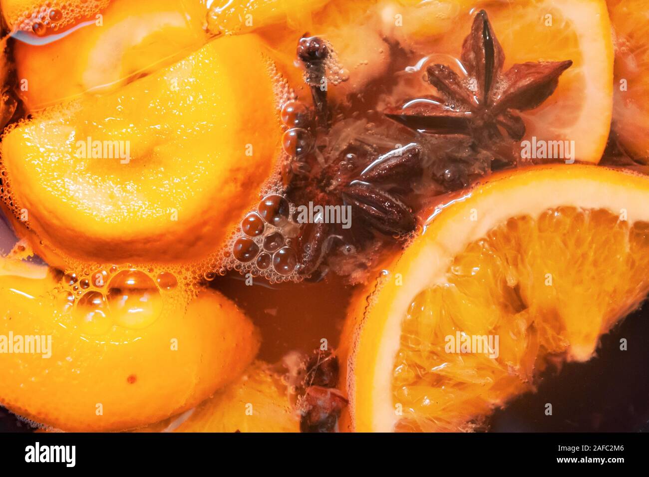 Die heiße alkoholische Glühwein mit Orangen und Gewürzen. Weihnachten Getränke kochen in der metallwanne. Glintwine von Rose Wein mit Zitrusfrüchten, Nelken Stockfoto