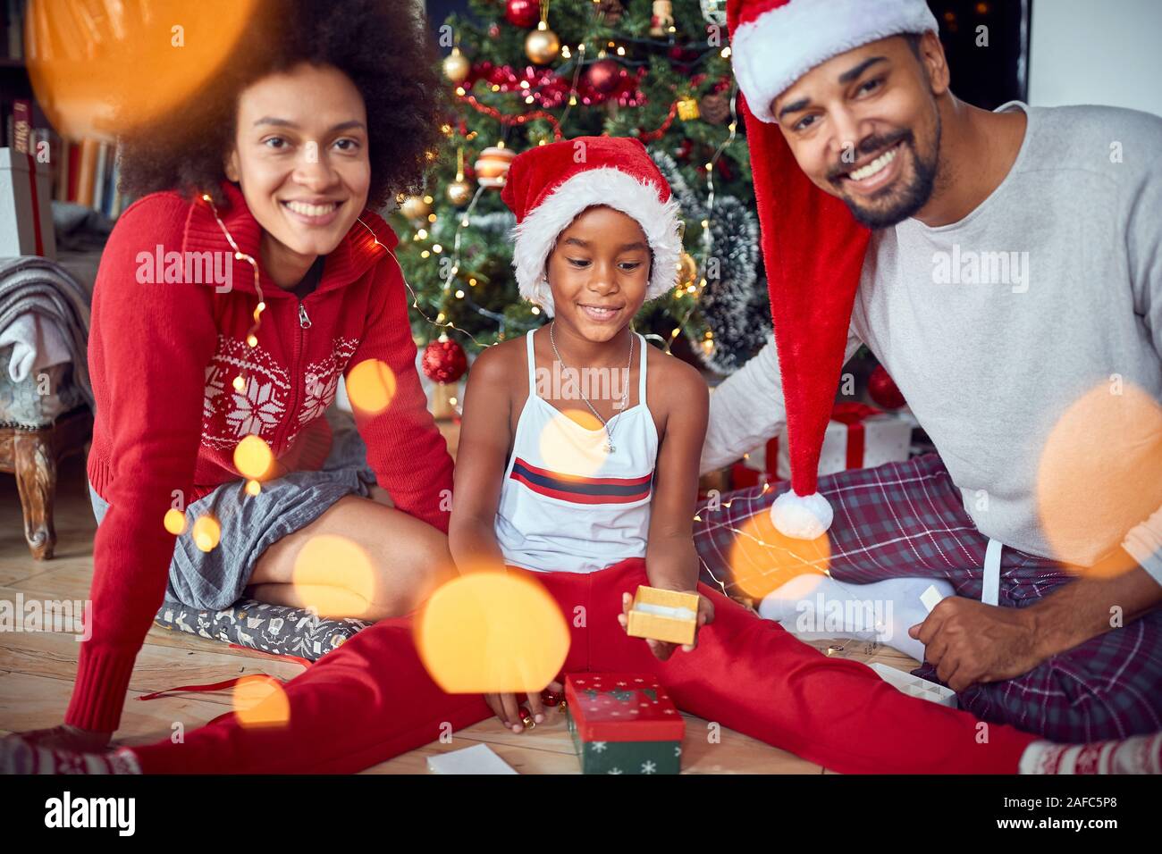 Glückliche Familie mit Mädchen an der Weihnachtszeit - Weihnachtszeit Stockfoto