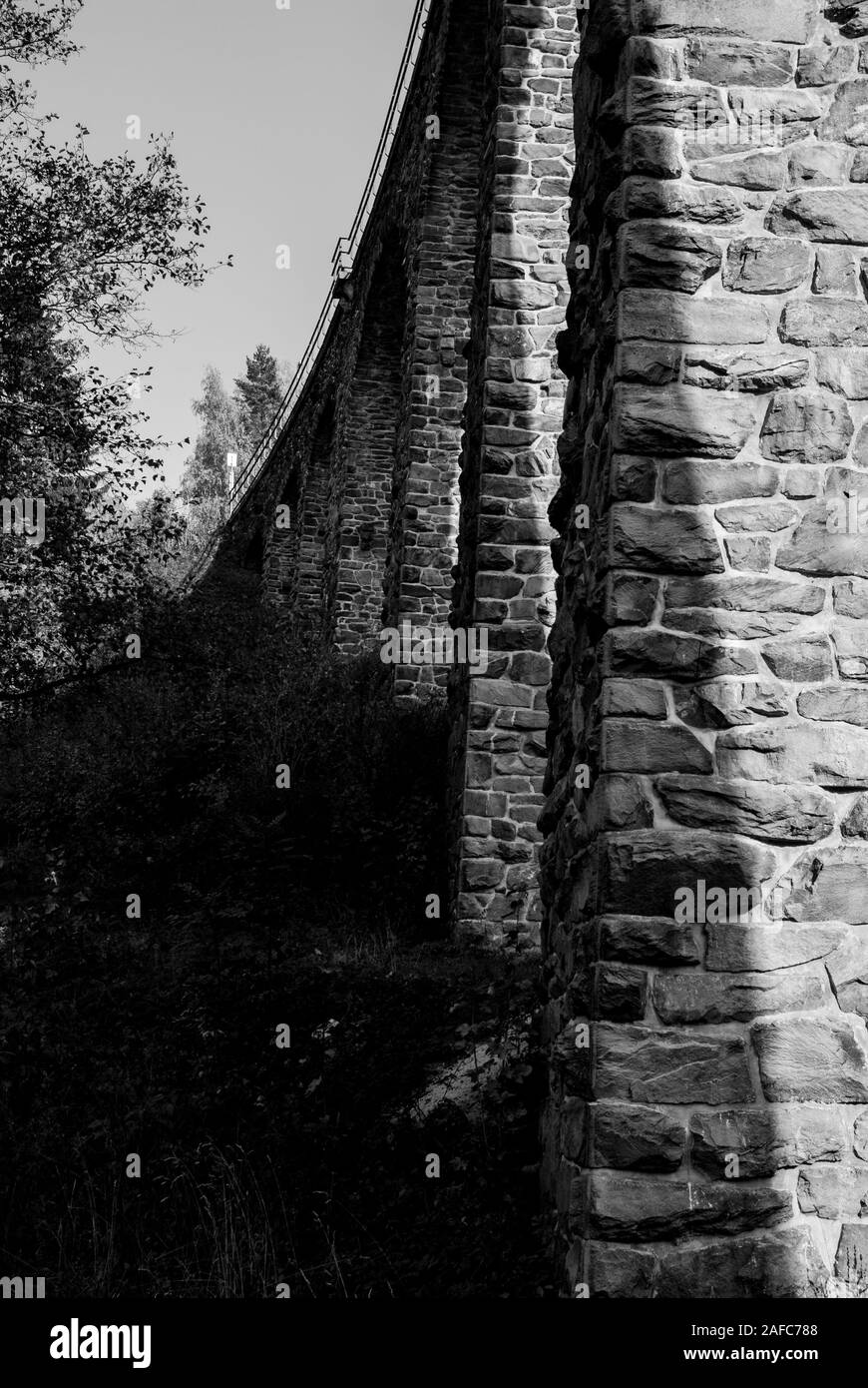 Alte steinerne Brücke, Foto in Schwarz und Weiß. Die höchste Eisenbahn funktionale Brücke in der Tschechischen Republik. Gewölbte bogenförmige Brücke über einen langen Tal Stockfoto