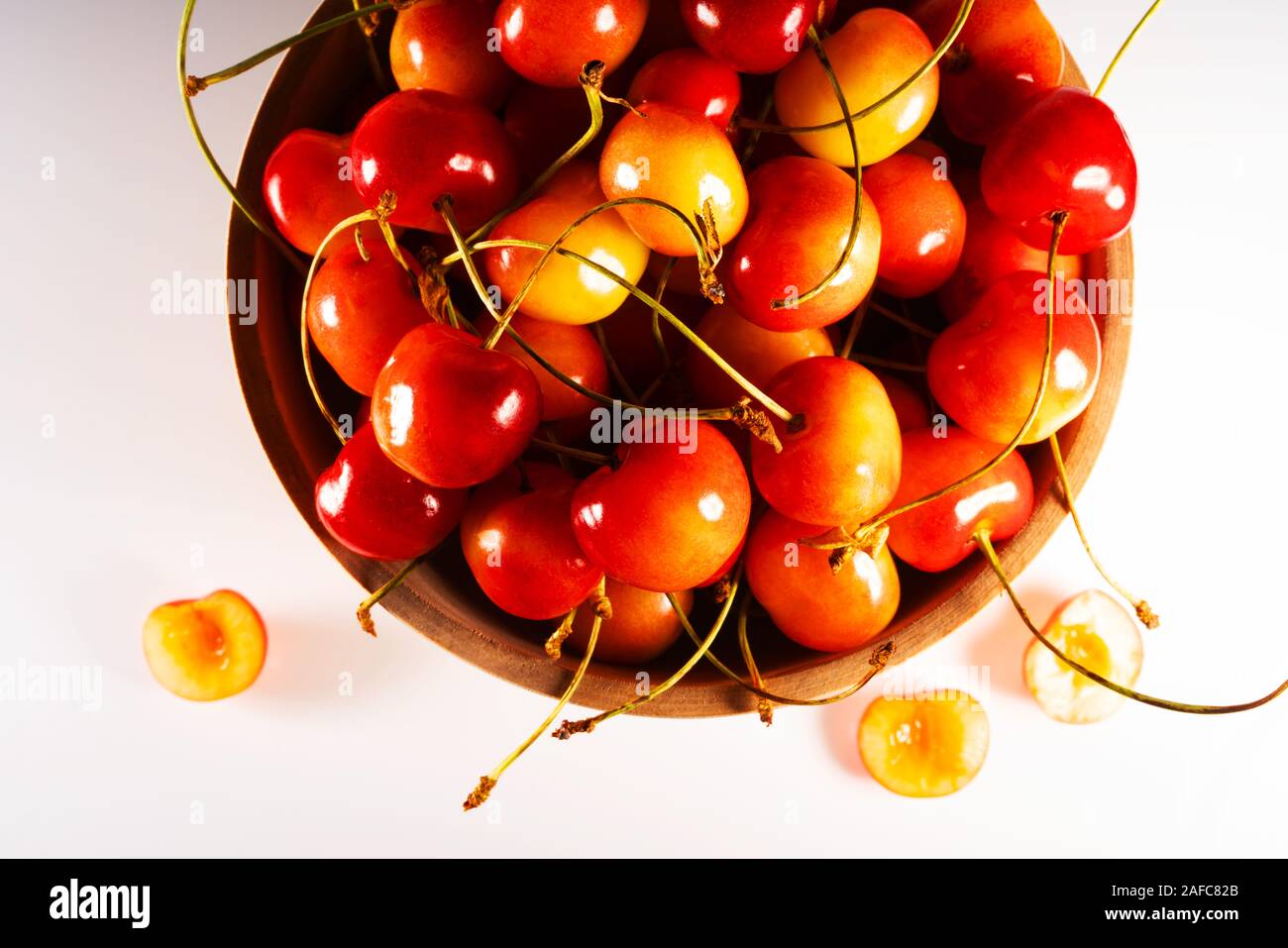 Frische süße reife Kirschen in einer Holzschale isoliert auf weißem Grund. Draufsicht. Stockfoto