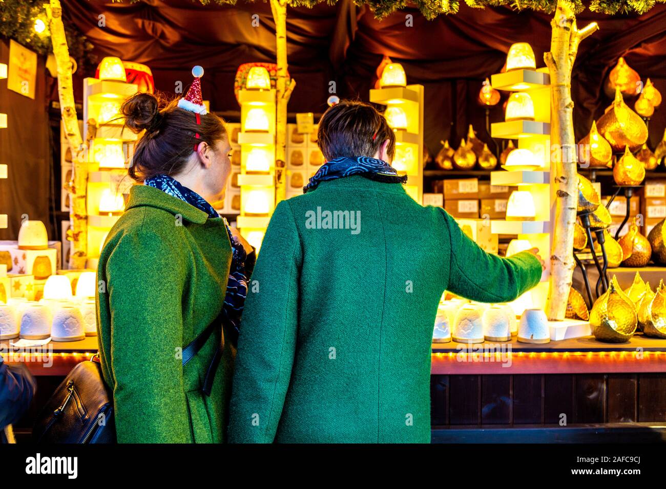 Zwei Frauen in ein festliches Weihnachten souvenir stall Southbank Centre Winter Festival und Weihnachtsmarkt, London, UK suchen Stockfoto