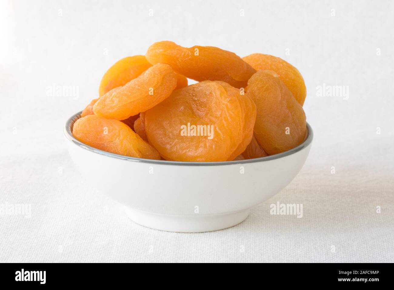 Getrocknete Aprikosen in eine Schüssel geben. Stockfoto